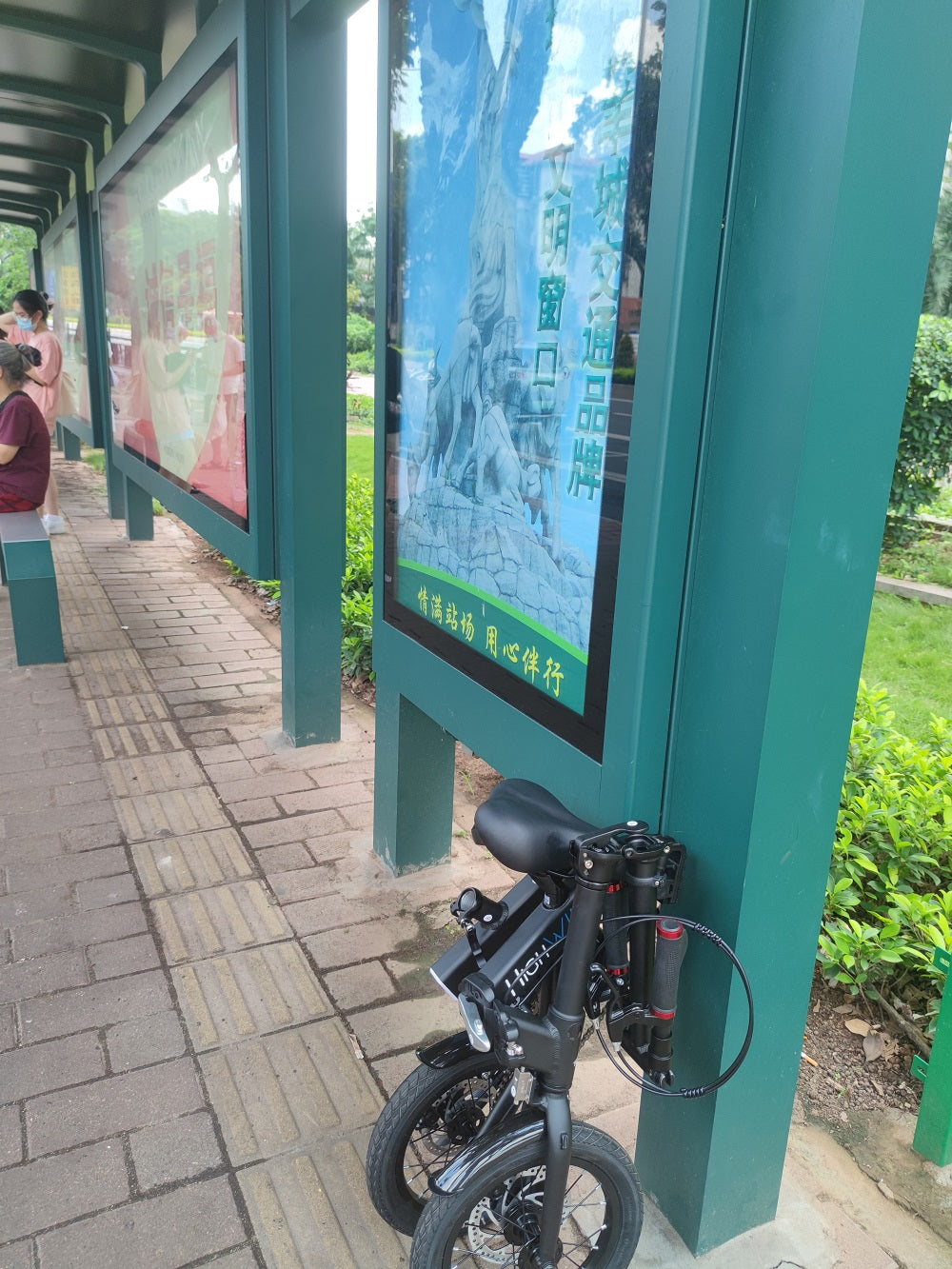 Waiting for the bus with a folding bike named Highwing Bike.